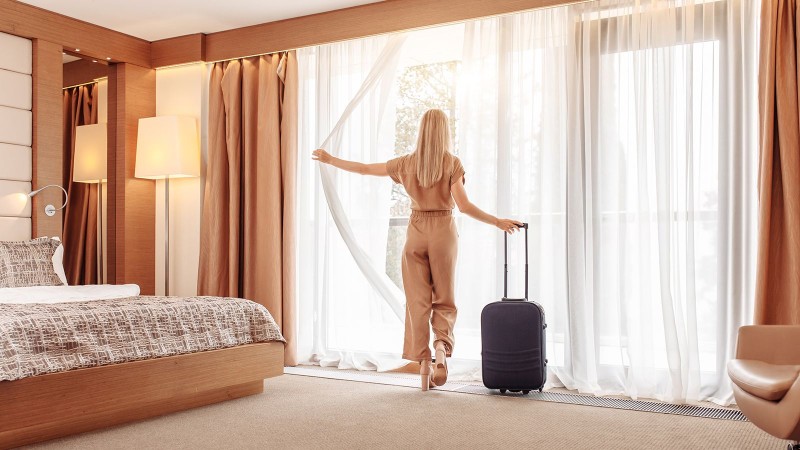 woman opening hotel bedroom window