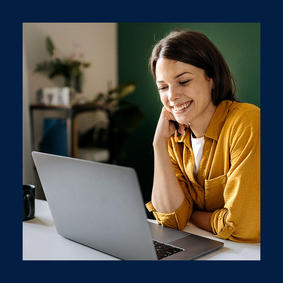 Woman smiling at laptop screen