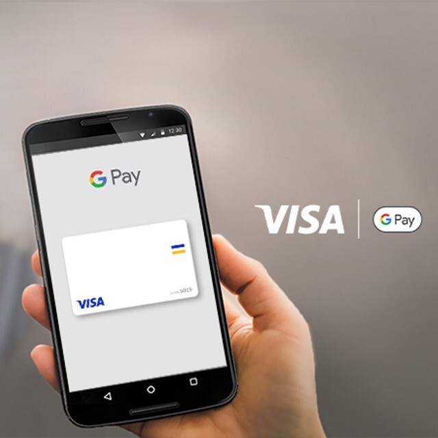 holding phone next to visa gpay logo